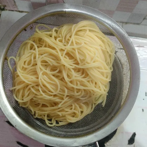 Rebus pasta spaghetti, tambahkan 1 sdm minyak dalam air rebusan, setelah matang dan lunak angkat lalu tiriskan.