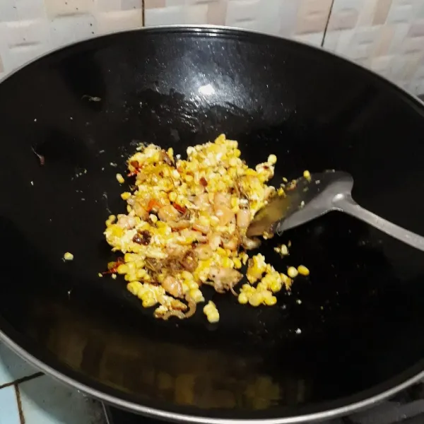 Masukkan jagung, campurkan dengan telur dan tumisan udang, aduk rata. Masak sebentar hingga jagung berubah warna.