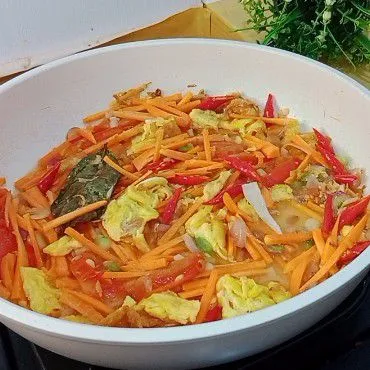 Masukkan wortel, cabai merah, tomat dan sedikit air kemudian masak hingga sedikit layu.