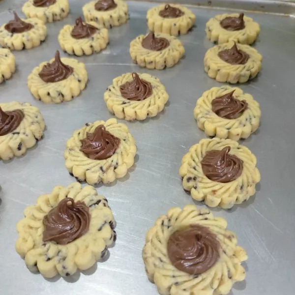 Keluarkan dari loyang, tunggu cookies dingin baru beri selai coklat panggang kembali hingga matang kira kira 15 menit sesuai suhu oven.