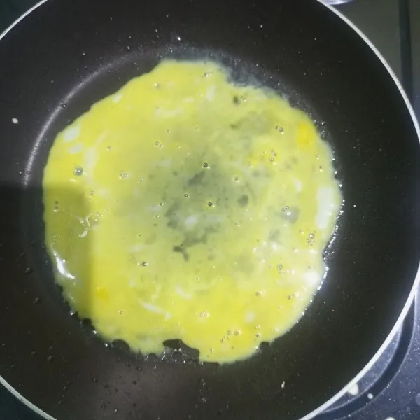 Ceplok 1 telur dan ratakan diatas permukaan teflon, beri sejumput garam, goreng hingga matang lalu angkat.