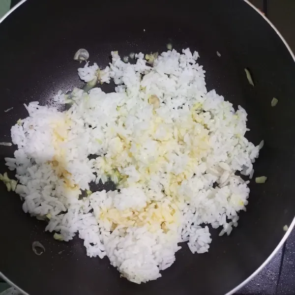 Masukkan nasi dingin dan telur yang sudah dikocok lalu tumis sebentar