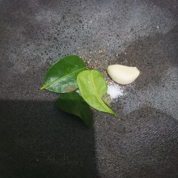 Siapkan daun jeruk, bawang putih, merica dan garam diatas cobek, lalu ulek hingga halus