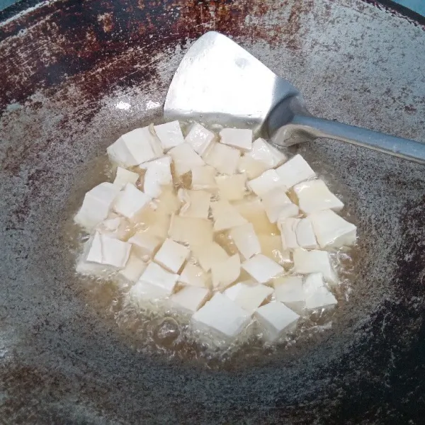 Siapkan tahu putih, cuci bersih dan potong kecil. Rendam dengan secukupnya garam dan air. Siapkan wajan dan goreng.