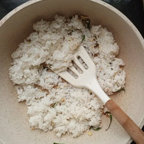 Masukkan nasi, aduk rata. Tambahkan kaldu jamur.