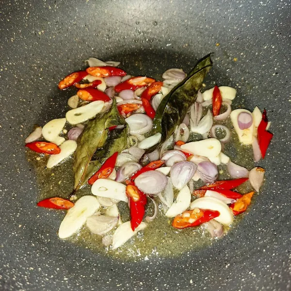 Tumis bawang merah, bawang putih, cabai dan daun salam sampai harum.