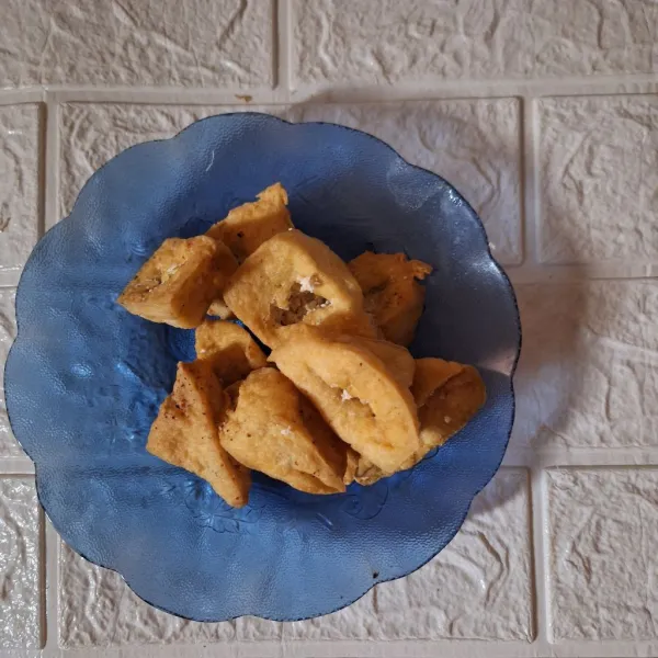 Langkah selanjutnya, belah tahu yang sudah digoreng di tengahnya kelurkan isian tahunya sampai bener-bener kopong.