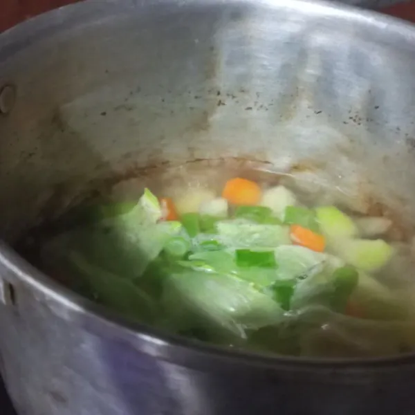 Masukkan daun kol, daun bawang dan bumbui dengan kaldu ayam, gula. Aduk rata, masak hingga matang