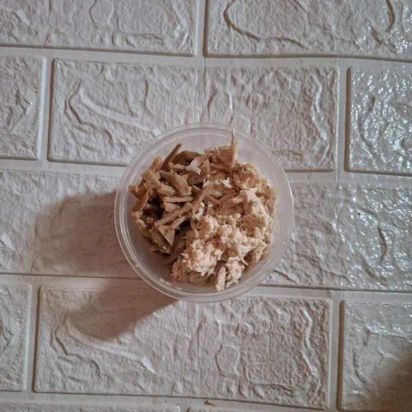Rebus dada ayam, kemudian suwir-suwir menggunakan garpu dan potong memanjang bakso.