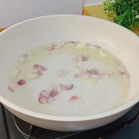Panaskan minyak goreng lalu tumis bawang merah dan bawang putih hingga harum