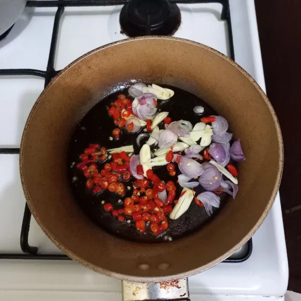 Tumis irisan bawang merah, bawang putih, cabe rawit dan cabe merah keriting hingga harum