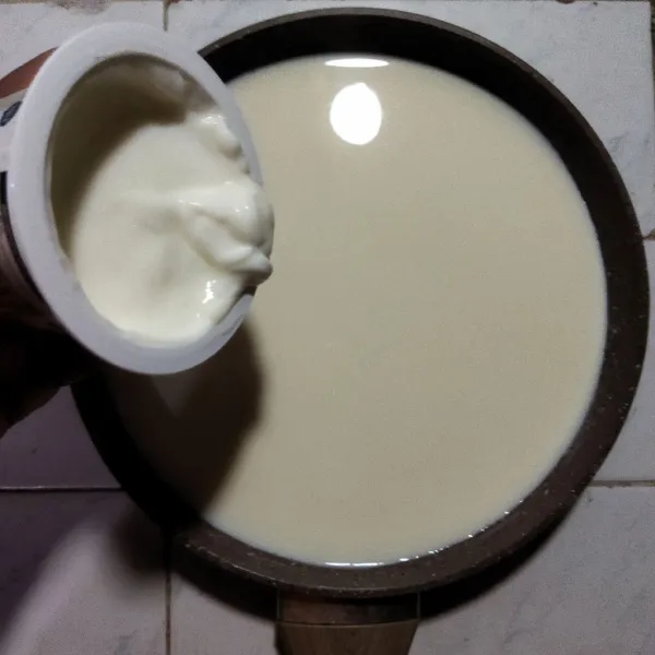 Dalam wadah masukkan sedikit susu cair hangat bersama plain yogurt dan susu bubuk, aduk rata dan saring jika perlu. Lalu masukkan kembali kedalam panci susu hangat, aduk rata.