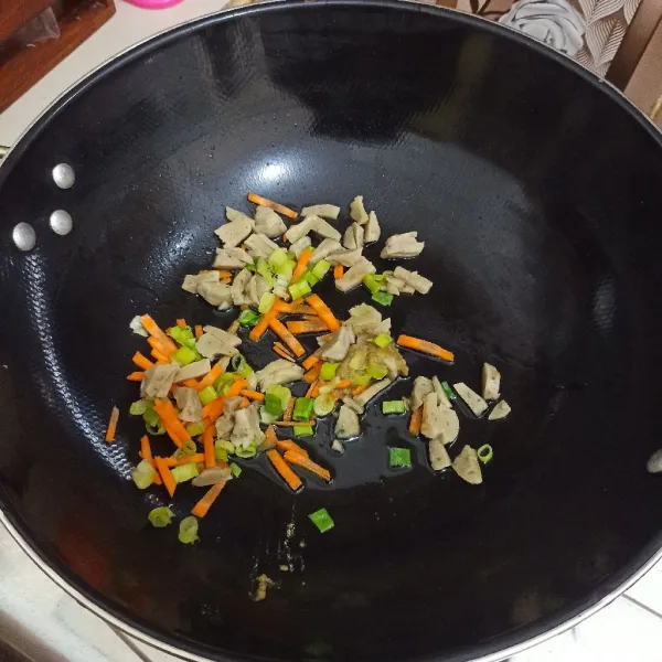 Tumis bawang putih giling hingga harum, masukkan wortel, daun bawang dan bakso ayam, aduk merata.