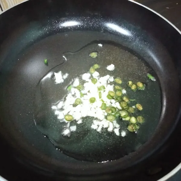 Tumis bawang putih dan cabe hijau hingga harum.