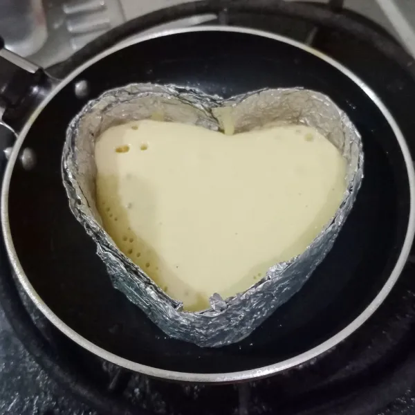Oles tipis pan dengan mentega lalu lap dengan tisu dapur.Tuang ± 1 sendok sayur adonan pancake ke dalam cetakan, masak dengan api kecil.Tunggu hingga mulai berpori/berlubang kecil-kecil.