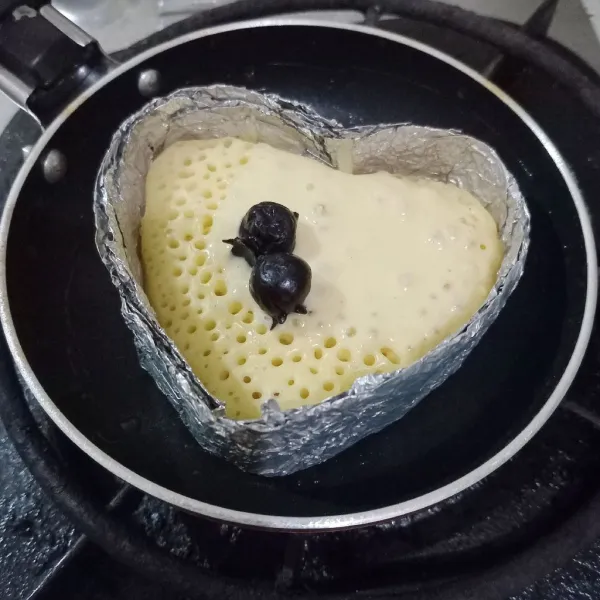 Setelah mulai berpori/berlubang kecil masukkan buah blueberry. Masak hingga permukaan pancake mulai kering, lalu balik masak selama ± 30 detik. Angkat. Sajikan bersama sirup maple.