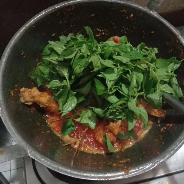 Masukkan kemangi, lalu tambahkan sedikit air, masak sampai kemangi layu.