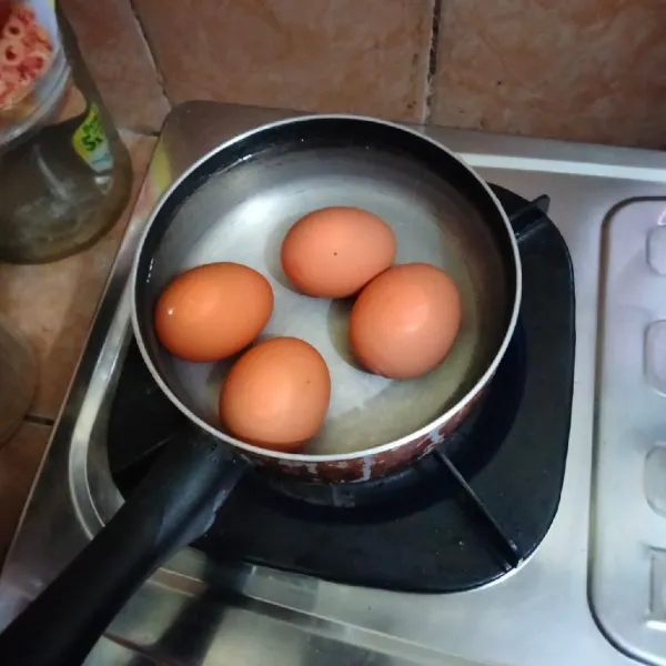 Rebus telur hingga matang, kemudian angkat dan tiriskan, lalu kupas sisihkan.