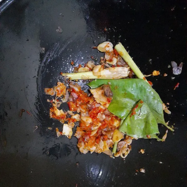 Tambahkan cabe merah halus, daun salam, serai, lengkuas, dan cabe iris. Tumis merata.