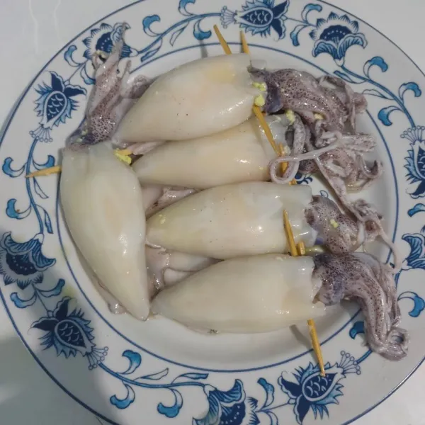 Masukkan ke dalam perut cumi isian yang sudah dibuat. Sematkan bagian kelapa dengan tusukan sate.
