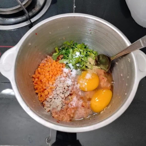 Setelah itu masukkan wortel, daun seledri, telur, lada bubuk, kaldu bubuk, dan garam. Aduk rata dengan sendok.