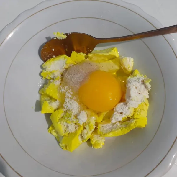 Masukkan ke dalam wadah telur, tahu, lada, dan penyedap rasa. Aduk merata.