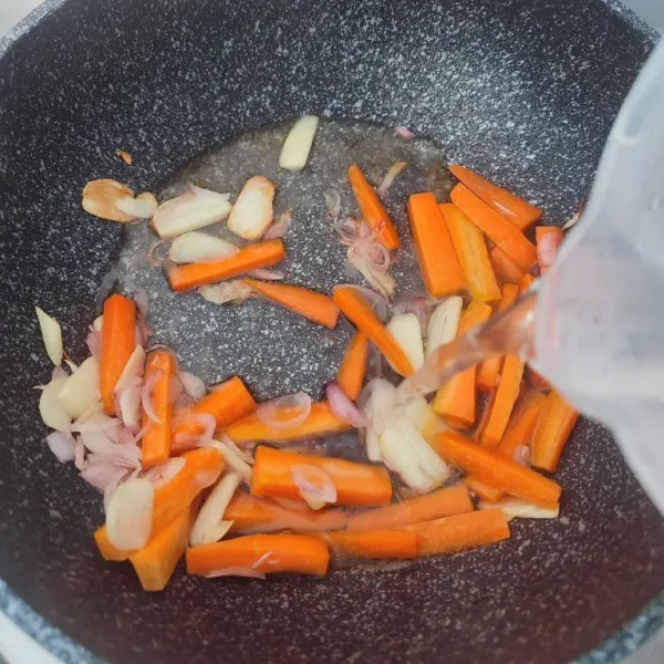 Masukkan potongan wortel dan air. Rebus hingga wortel empuk.