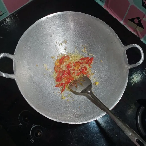 Dalam minyak bekas telur tadi, tumis bawang putih dan juga cabe.