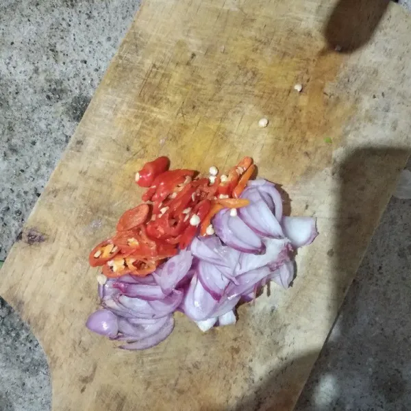 Membuat sambal kecap, iris bawang merah dan cabe nya.