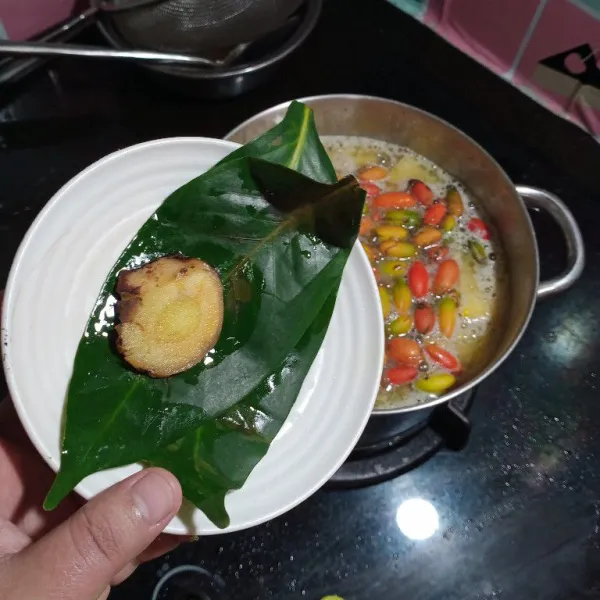 Masukan buah melinjo, daun salam dan laos.