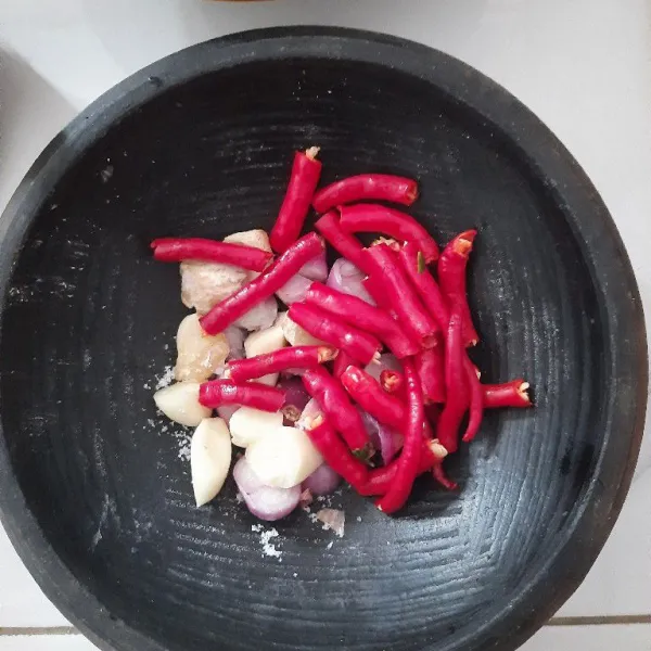 Haluskan bawang merah, bawang putih, kemiri, cabai rawit kriting tambahkan sejumput garam untuk memudahkan saat diulek