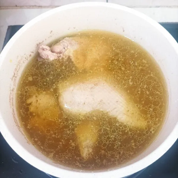 Rebus ayam dengan sebagian bumbu halus sampai matang empuk.