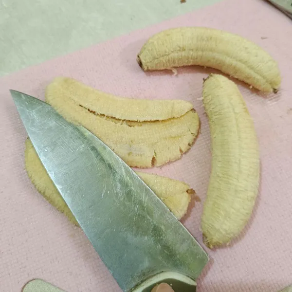 Kupas pisang, lalu tekan dengan pisau hingga memipih.