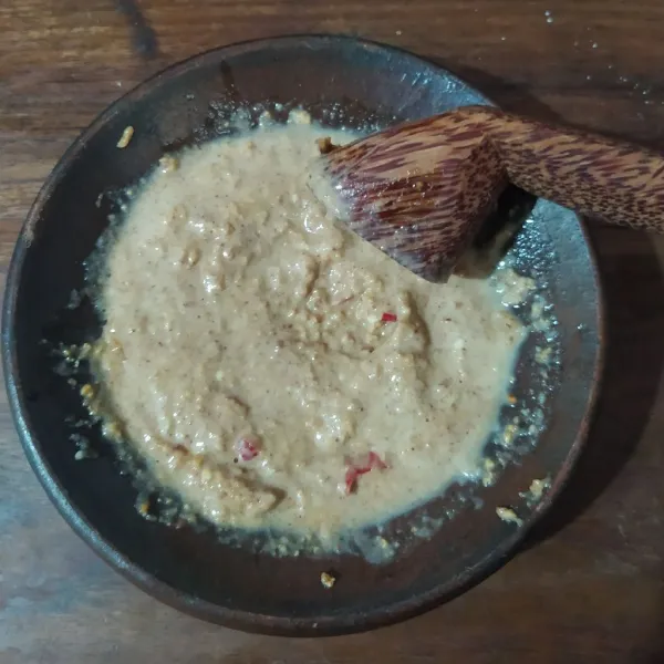 Haluskan kacang tanah, bawang, cabe rawit, dan garam. Beri gula merah dan pasta asam Jawa. Beri air matang secukupnya.
