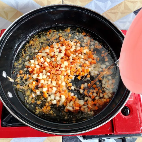 Panaskan secukupnya minyak goreng lalu tumis bumbu halus hingga harum. Masukkan wortel kentang dan secukupnya air. Masak hingga mendidih dan wortel empuk.