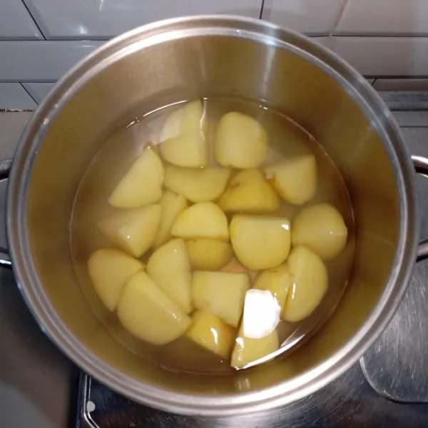 Cuci kentang, kupas kulitnya lalu potong besar-besar. Kemudian rebus kentang hingga matang.