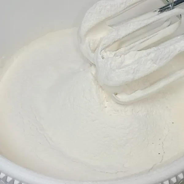 Kemudian masukkan tepung dan susu bubuk, saring terlebih dahulu. Mixer kembali dengan kecepatan rendah sampai tercampur merata