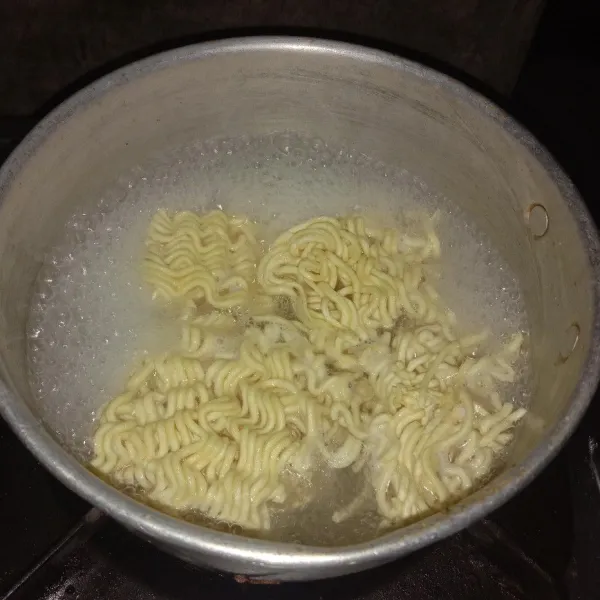 Didihkan air, lalu rebus mie sampai setengah matang, aduk sesekali