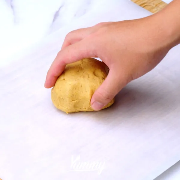 Letakkan adonan di atas baking paper lalu roll hingga ketebalan yang diinginkan, lalu potong kotak-kotak, oles adonan dengan kuning telur, tambahkan almond dan gula