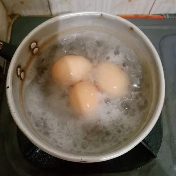 Rebus telur sampai benar-benar mateng. Kemudian kupas kulitnya