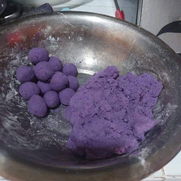 Haluskan ubi ungu lalu tambahkan tapioka, garam dan vanili. Aduk rata lalu bentuk bulatan sesuai selera