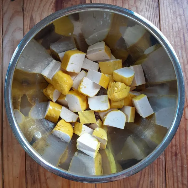 Potong-potong tahu sesuai selera,kemudian beri 2 cubit garam, aduk rata. Diamkan selama 5-10 menit.