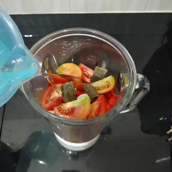 Masukkan cabai merah, cabai rawit, bawang merah, bawang putih, tomat, terasi, dan air ke dalam blender.