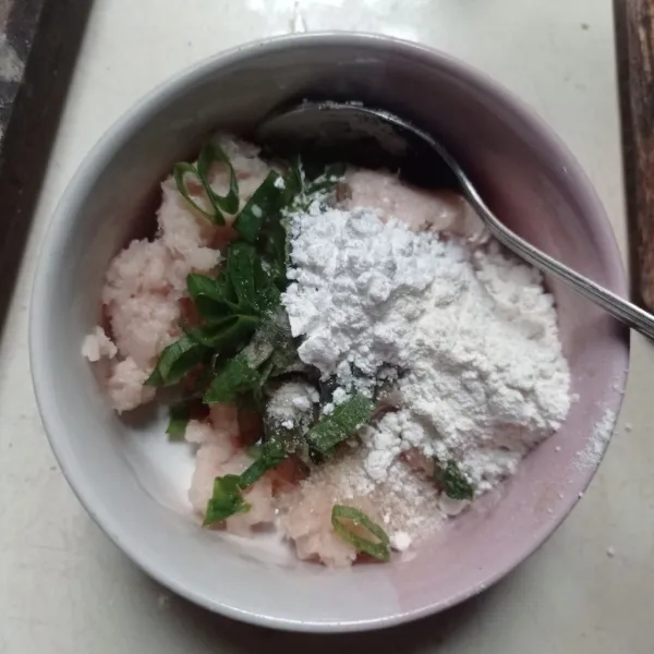 Pindahkan kemangkok tambahkan irisan daun bawang, tepung tapioka, tepung terigu, saus tiram, garam, gula, lada dan kaldu bubuk, aduk sampai rata
