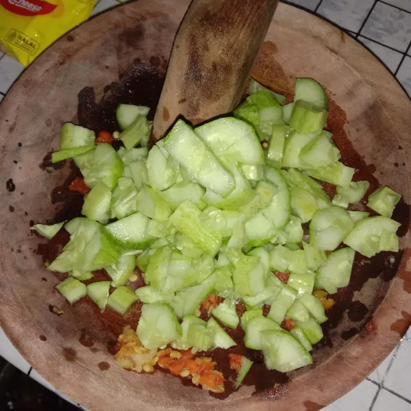 Potong potong timun secara acak dan kecil, masukan kedalam cobek