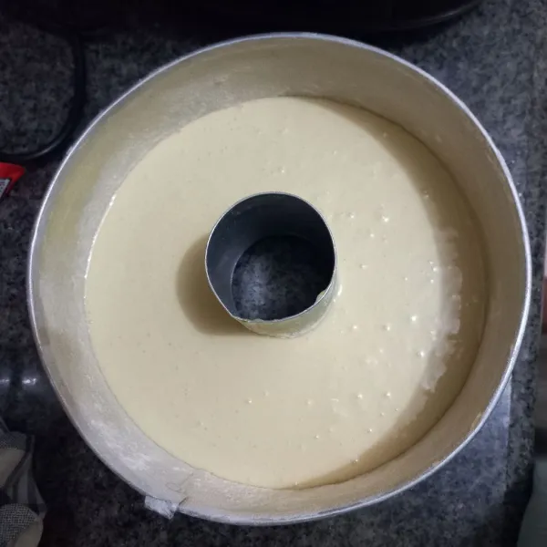 Bagi adonan menjadi 3 bagian, tuang adonan putih ke dalam loyang yang telah diolesi margarin dan taburan tepung terigu