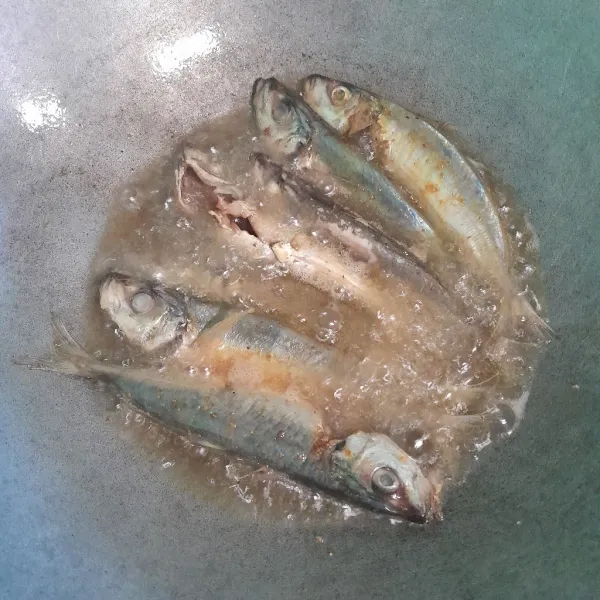 Goreng ikan sampai kering di minyak panas