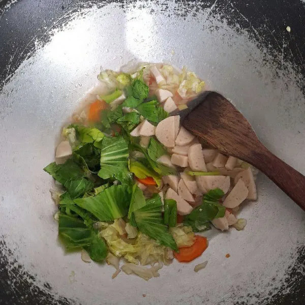 Tambahkan sawi hijau dan bakso ayam, masak hingga sayur matang