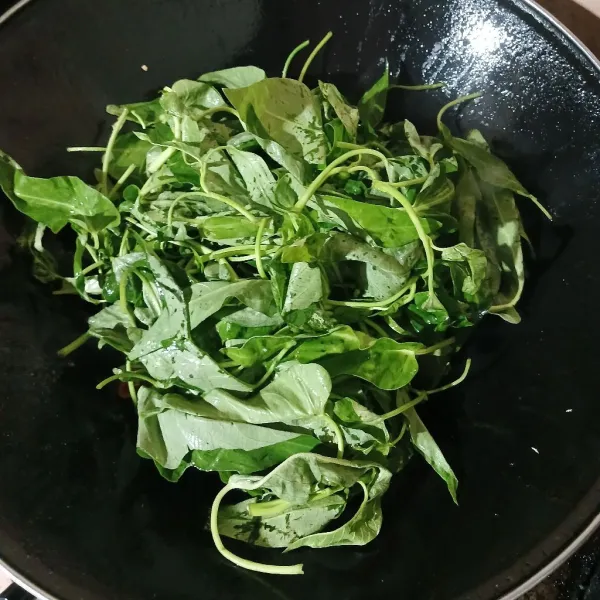 Masukkan kangkung, kemudian aduk rata. Jika perlu, beri sedikit air.