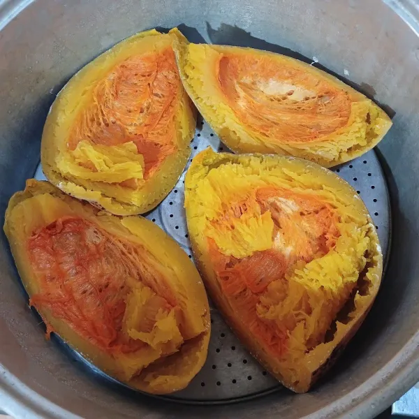 Belah labu kuning menjadi 4 bagian. Kemudian, kukus hingga matang. Keruk dagingnya, letakkan di wadah.